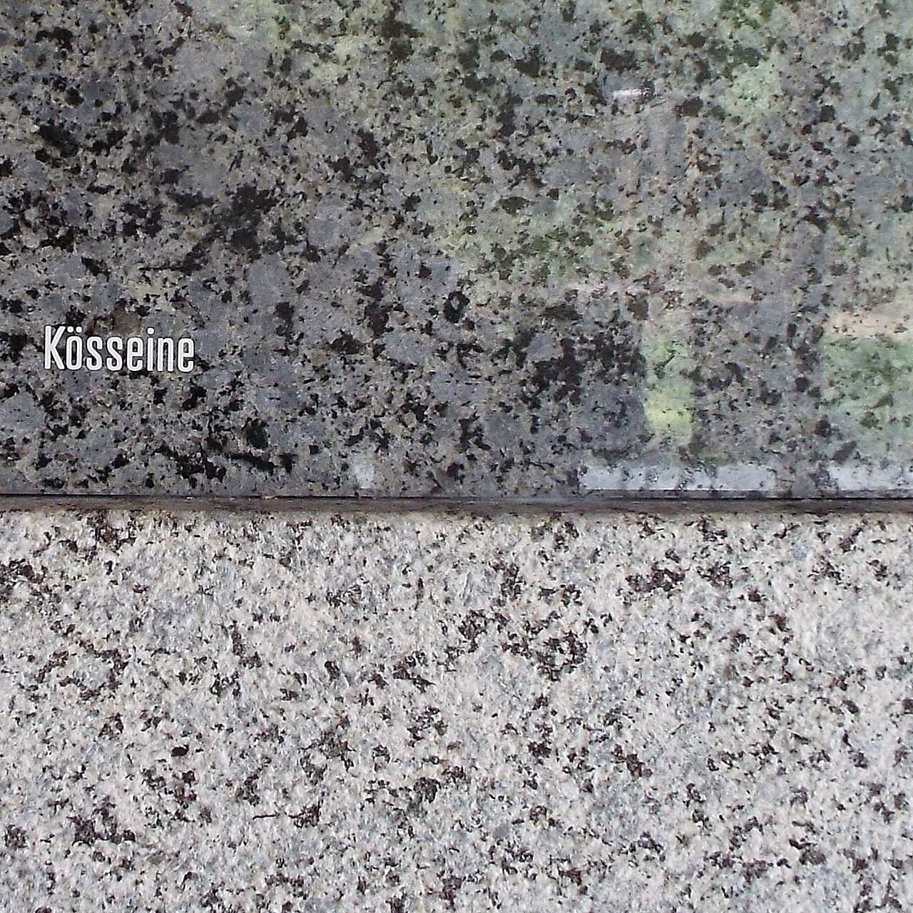 A cut and polished granite surface showing interlocking pale and dark crystals a few millimetres across.
