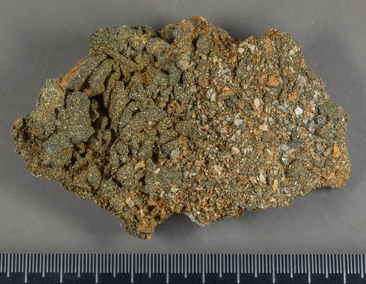 Brassy metallic cubic pyrite crystals on a pale mineral matrix.